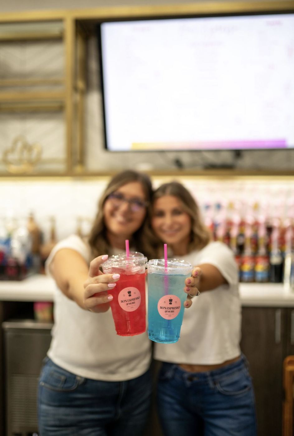 Two colorful Bo's drinks held toward camera